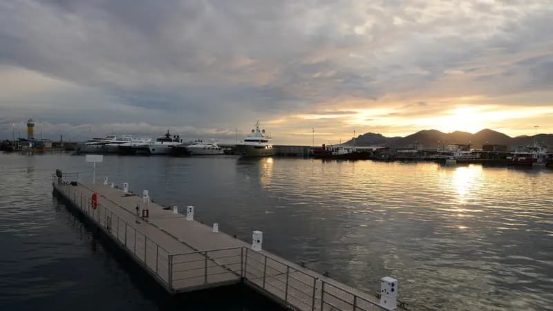 Gün batımında Cannes Vieux Port’ta yüzer iskele ve bağlı yatlar