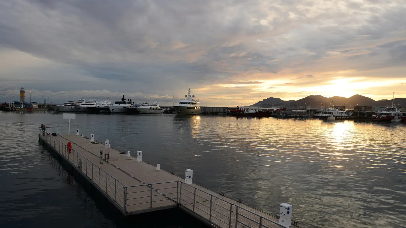 Gün batımında Cannes Vieux Port’ta yüzer iskele ve bağlı yatlar
