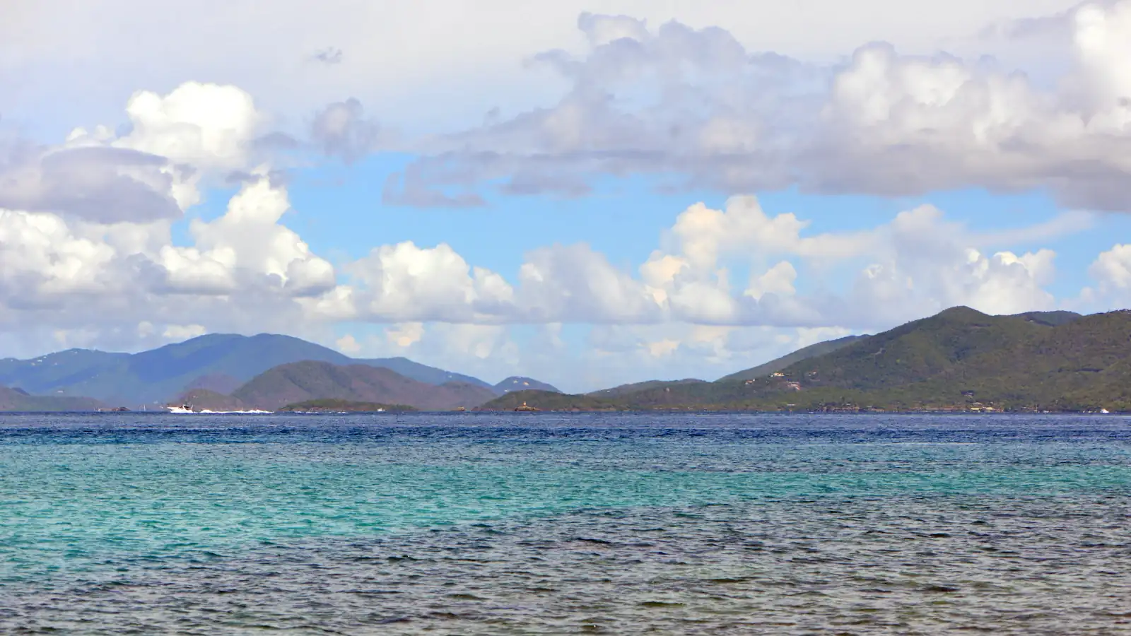 a large body of water with mountains in the background