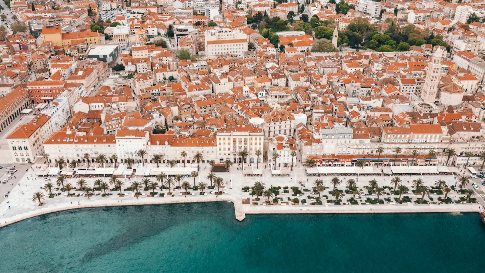 an aerial view of a city next to a body of water