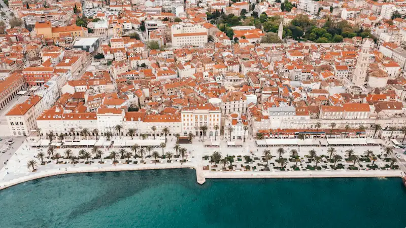 an aerial view of a city next to a body of water