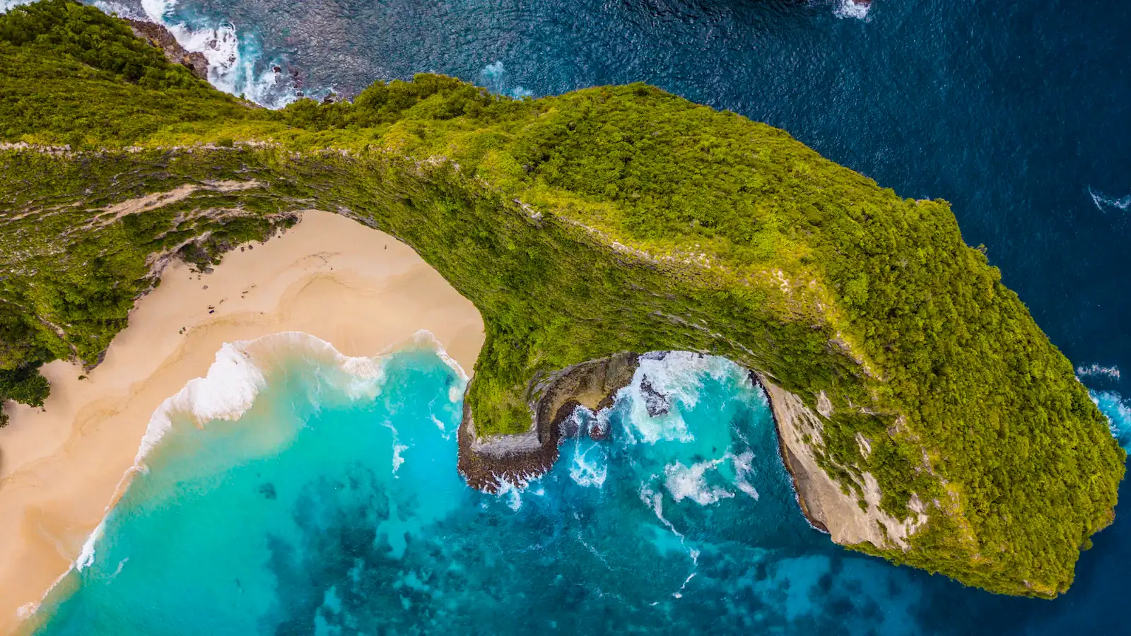 green mountain surrounded by body of water