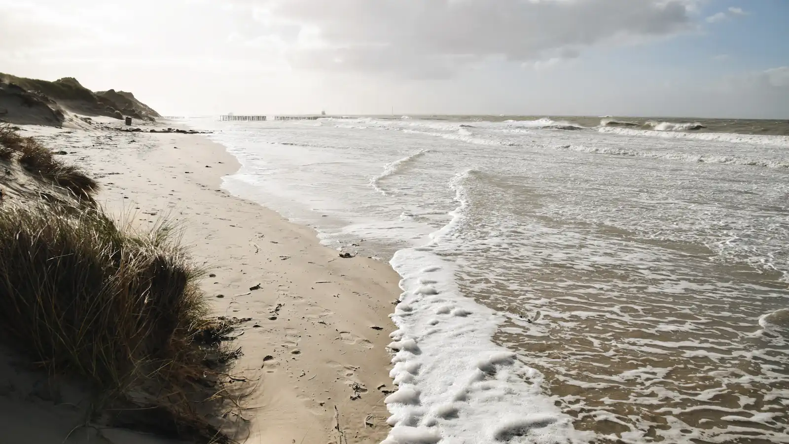 a sandy beach with waves coming in to shore