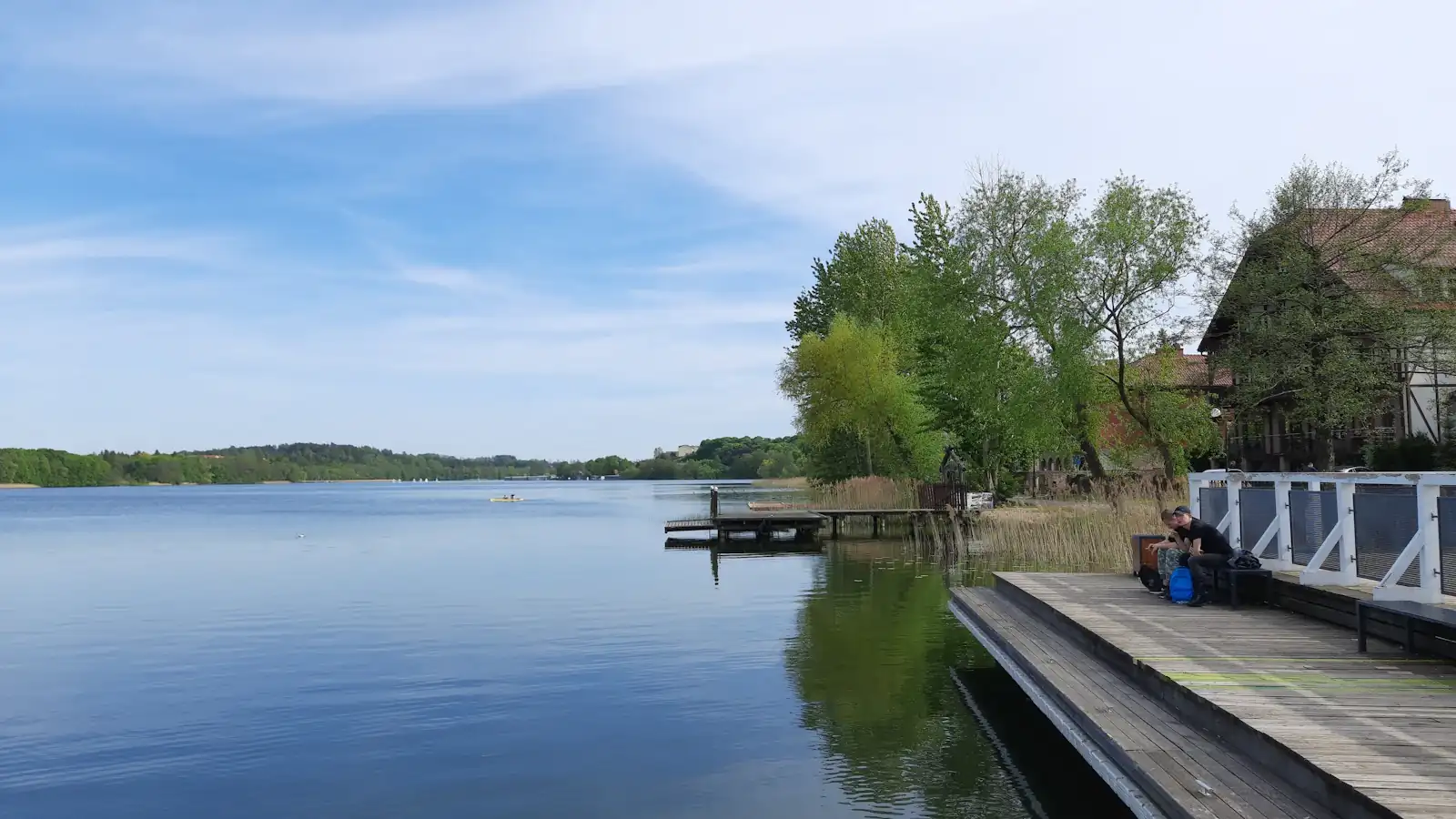 a person sitting on a dock next to a body of water