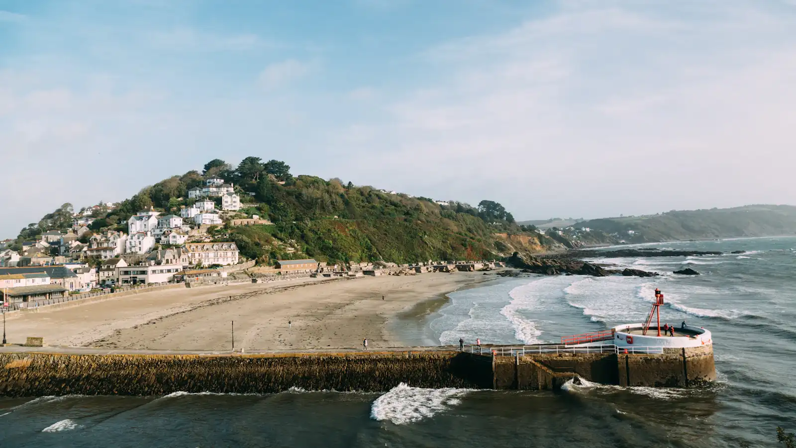 a view of a beach with a small hill in the background